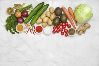 An assortment of vibrant farm vegetables and fresh herbs on a marble surface for healthy cooking
