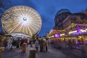 Ferris wheel at the winter village, Christmas market at dusk, St Elisabeth's Church on the right,