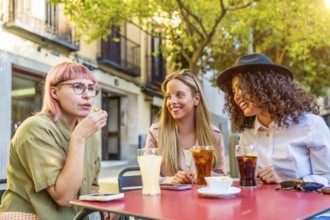 Modern diverse stylish woman eating snacks and drinking in an outdoor cafeteria