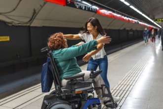 Happy disabled woman meeting a chinese female friend in the metro platform smiling and embracing