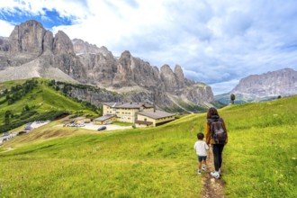 Tourists enjoying a summer hike through the stunning dolomites near gardena pass, italy, surrounded