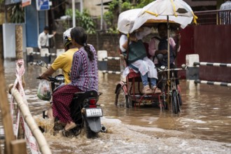 Commuters wade through a flooded street after heavy rains in Guwahati, India on April 28, 2025