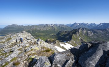 View of mountain landscape, mountain panorama, mountaineer at the summit of Rundfjellet, lake