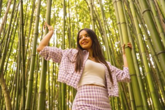 Young caucasian girl with a pink skirt in a bamboo forest. Enjoying summer holidays in a tropical