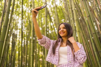 Young caucasian girl with a pink skirt in a bamboo forest. Enjoying summer vacation in a tropical