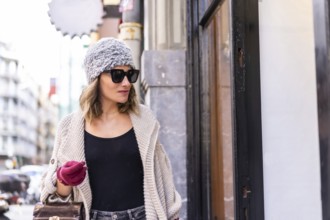 Lifestyle, young Caucasian blonde girl enjoying and smiling in the city in winter. Strolling with
