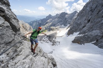 Mountaineer with helmet in a secured via ferrata, Zugspitze via ferrata, ascent to the Zugspitze,