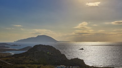 Glittering sea in front of islands in the evening light with dawning sky, Arkasa, west coast,