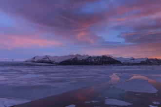 Dawn over frozen lake and mountains, winter, Jökulsarlon, Vatnajökull, Iceland, Europe