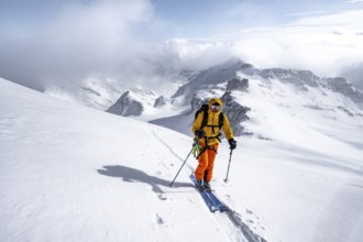 Ski tourers climbing the Wildhorn, Snowy mountain landscape and fog, Bernese Alps, Bernese