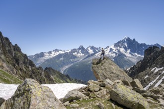 Mountaineer standing on a rock, mountain landscape with mountain peak Aiguille Verte, Mont Blanc