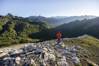Mountaineer in front of mountain landscape at sunrise, view of mountain peaks of the Venediger