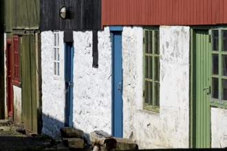 Detail of traditional whitewashed houses with colour-painted timber cladding, Mykines Island, Faroe