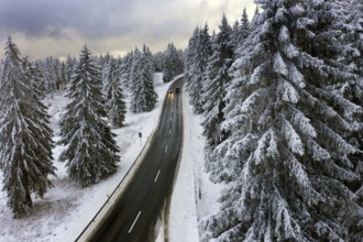 Aerial view, road leads through a snow-covered forest area near Sankt Andreasberg, 14 December 2019