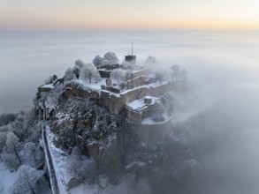 Aerial view of the Hegau volcano Hohentwiel with Germany's largest fortress ruins on a cold, foggy