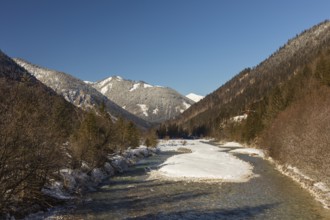 The Riss creek flowing through a snow covered landscape in the Eng valley. Sunny day with blue sky