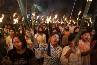 Members of the All Assam Students' Union (AASU) take part in a flaming torch rally and shout