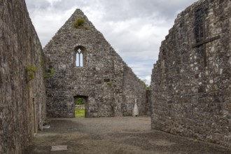 Historic stone ruin with Gothic style, small windows and a cross, Urlaur Abbey