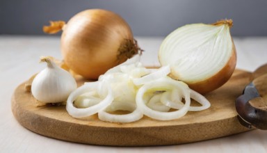 Vegetables, onion, Allium cepa, freshly sliced onion rings and finely chopped onion on a wooden