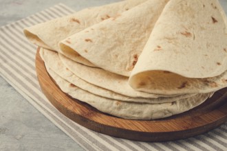 A stack of Mexican tortillas, on a gray table, top view, close-up, no people