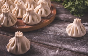 Raw khinkali, Traditional Georgian dish, on a wooden table, selective focus, rustic, no people