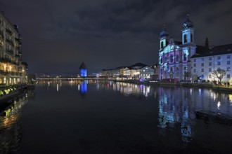 Water tower and Jesuit church on the right with light installation, on the Reuss at dusk, Old Town,