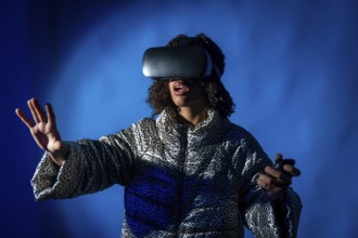 Young woman wearing a vr headset and holding controllers, expressing surprise while immersing in
