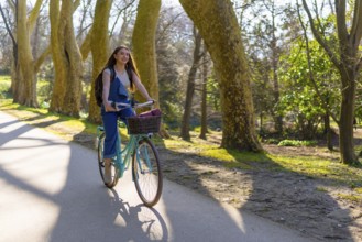 Student enjoying cycling in a park during a sunny spring day, promoting sustainable mobility and