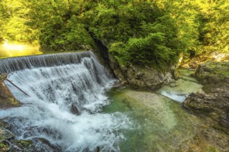 Stunning waterfall cascading into the crystal clear turquoise waters of vintgar gorge, a natural