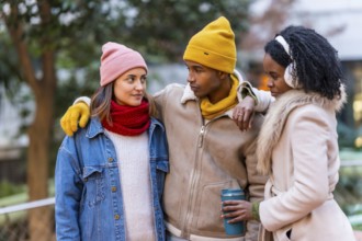 Group of cheerful multi ethnic friends wearing winter clothes, walking together on a cold winter
