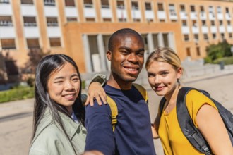 Frontal view of three multi-ethnic university students taking selfie in the campus