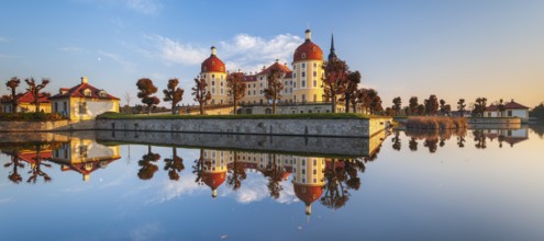 Moritzburg Castle in autumn under a blue sky, reflection in the castle pond, hunting lodge of