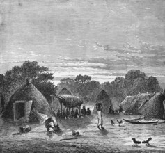 Village view with huts in the tropics, locals sitting in the shade, woman carrying a bowl on her