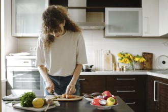 Woman chopping baby carrot in the kitchen
