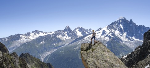 Mountaineer standing on a rock, mountain landscape with mountain peak Aiguille Verte, Mont Blanc