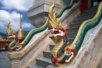 Dragon on staircase of tower with top of Chedi highest building in temple complex buddhist
