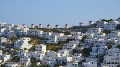 Traditional windmills line up next to white houses on a sunny hillside, Chora, Astypalea,