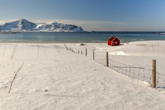 Red hut, snowy landscape, sea, mountains, Lofoten, Northern Norway, Norway, Europe