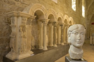 Stone female head in the museum at Gellone Abbey, also Saint-Guilhem-le-Désert Monastery,