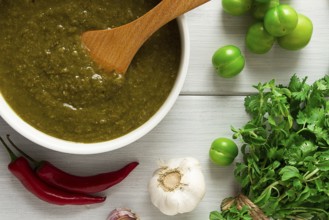 Tkemali sauce, traditional Georgian cuisine, green cherry plum, with ingredients for sauce,