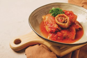 Stuffed cabbage rolls, with minced meat, in tomato sauce, on a beige background, food and drink,