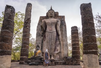 Tourist in front of the giant standing Buddha in the temple Wat Saphan Hin, UNESCO World Heritage