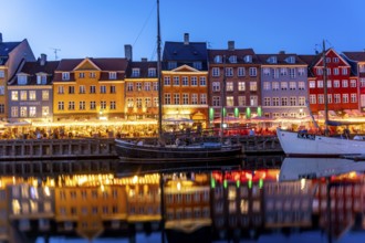 Colourful houses, restaurants and historic ships on the Nyhavn canal and harbour at dusk,