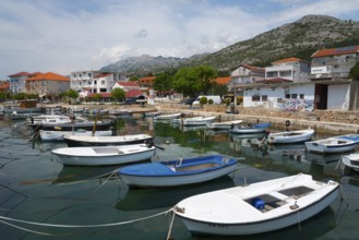 Various boats in a harbour surrounded by mountains and a quiet village panorama, Starigrad,