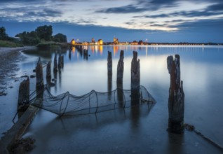 View at dusk over the Strelasund to the illuminated town of Stralsund with its churches and the