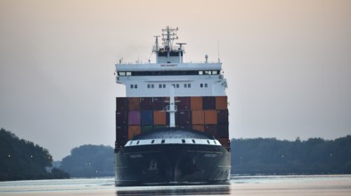 Container ship Nordic Porto sailing at sunrise in the Kiel Canal, Kiel Canal, Schleswig-Holstein,