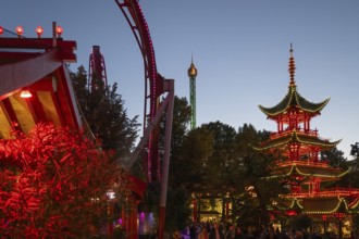 Red and yellow illuminated pagoda, roller coaster, Tivoli Amusement and Recreation Park,
