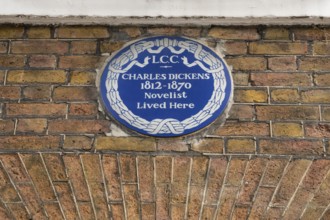 Blue plaque commemorating Charles Dickens on a brick wall, Charles Dickens Museum, 48-49 Doughty