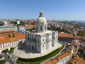 Central dome-shaped building in the foreground of a dense urban environment on a clear day,