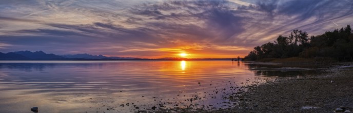 Panorama of a lake at sunset with dramatic clouds and bright colours, Chiemsee